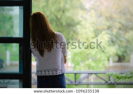 Depressed women. Asian beautiful girl standing at the window.