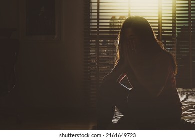 Depressed Women Sitting Head In Hands On The Bed In The Dark Bedroom With Low Light Environment, Dramatic Concept