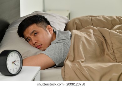 Depressed Young Asian Man Lying In Bed Cannot Sleep From Insomnia