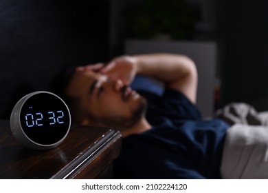 Depressed young Asian man lying in bed cannot sleep from insomnia. focus on clock - Shutterstock ID 2102224120