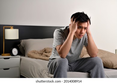 Depressed Young Asian Man Sitting In Bed Cannot Sleep From Insomnia