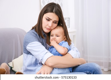 Depressed Young Woman With Cute Baby At Home