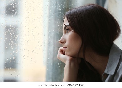 Depressed young woman near window at home, closeup - Shutterstock ID 606121190