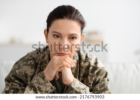 Depression In Military. Closeup Shot Of Thoughtful Female Soldier In Uniform Sitting On Couch And Resting Chin On Hands, Upset Army Woman Thinking About Something, Suffering PTSD Or Mental Issues