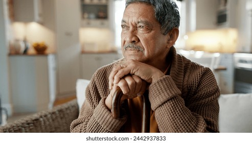 Depression, nostalgia and a senior man with a cane on a sofa in the living room of his retirement home alone. Memory, thinking and an elderly person with a walking stick in a house feeling sad - Powered by Shutterstock