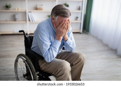 Depression in older adults with disability. Unhappy senior man in wheelchair crying from loneliness at home. Physically impaired male patient suffering from emotional problems - Shutterstock ID 1933026653