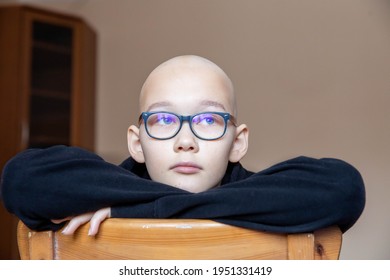 Depression Sad Bald Young Teen Girl With Cancer After Chemotherapy. Wearing Glasses And Black Hoodie, Sitting On Chair