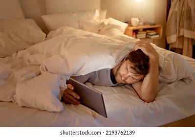 Depression, Sad Man Or Tablet Streaming In Home Bedroom Lockdown On Movie Subscription Channel. Stress, Anxiety Or Mental Health Person In Bed At Night And On Zoom App Call With Long Distance