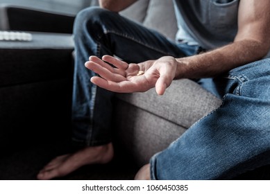 Depression Treatment. Close Up Of Pills Lying In A Palm Of A Moody Sad Man While Coping With Depression