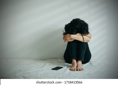 The Depression Woman  Hug Her Knee And Cry. Sad Woman Sat Alone With A Telephone Beside Her.