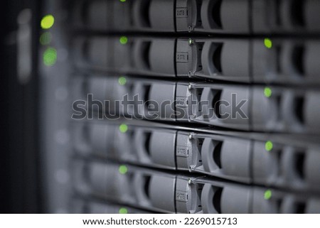 depth of field of gray disk slots of an it network attached storage device with green LEDs