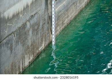 Depth marker counting surface level of sea. Vertical indicator of depth of river. Water meter. Low or high. Flood. Tide. Shortage of rain. Information bar. Global warming. Drought. Reservoir. Gauge.