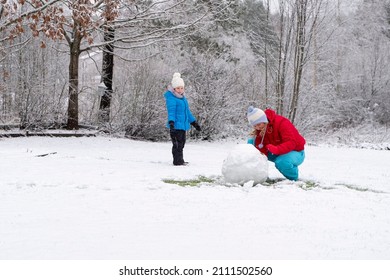 Depyat Snowman In Winter. A Young Woman And A 5-year-old Child Make A Snowman. Fun And Happiness With Family.