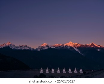 Deqin County, Yunnan province, China - November 8, 2021: white pagodas of feilai temple with Meili (or Mainri) snow mountains in background at sunrise in china's yunnan province