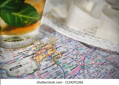 A Derby Hat And A Mint Julep Pictured With A Map Of Louisville, KY.