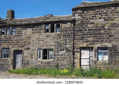 derelict abandoned old stone rural houses with broken windows and shabby wooden doors overgrown with weeds
