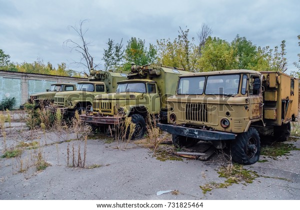 Derelict\
military trucks in abandoned military base\

