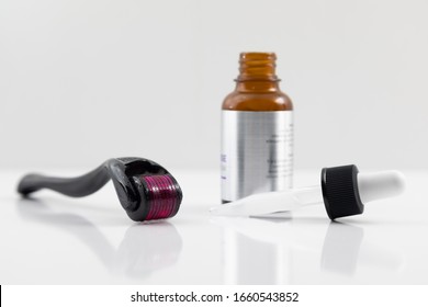  Dermaroller And A Serum Bottle Open Closeup On White. Shallow Depth Of Field.