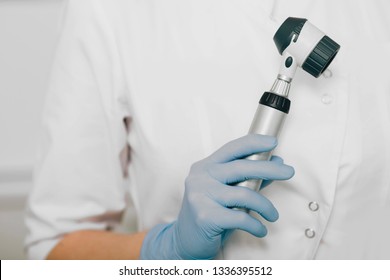 dermatologist with dermatoscope, close-up hand with dermatoscope
