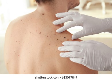 Dermatologist examining patient in clinic