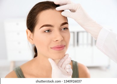 Dermatologist Examining Patient's Face In Clinic. Skin Cancer Checkup