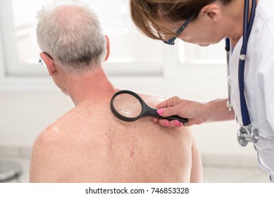 Dermatologist Examining The Skin On The Back Of A Patient