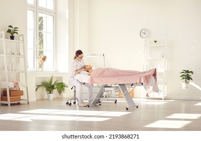 Dermatologist examining skin on woman's face. Beautician doing beauty procedure in her office. Young lady getting professional help during appointment visit to expert in cosmetology and dermatology