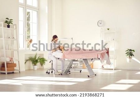 Dermatologist examining skin on woman's face. Beautician doing beauty procedure in her office. Young lady getting professional help during appointment visit to expert in cosmetology and dermatology