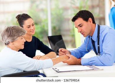 Dermatologist Inspecting Senior Patient Skin In Office