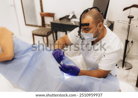 Dermatologist performs surgery to remove a mole on the leg