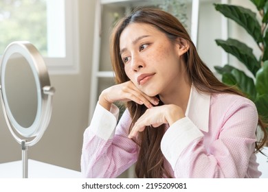 Dermatology, expression face worry asian young woman looking mirror hand touch facial at dark spot of melasma, freckles from pigment melanin, allergy sun. Beauty care, skin problem treatment, skincare - Shutterstock ID 2195209081