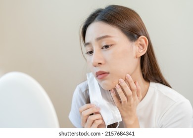Dermatology, puberty asian young woman, girl looking into mirror, allergy when wear mask and cosmetic, show squeezing pimple spot for removing from face.Beauty care from skin problem by acne treatment - Shutterstock ID 2157684341