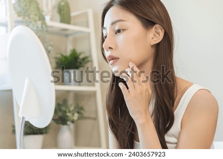 Dermatology, puberty asian young woman, girl looking into mirror, allergy when wear mask and cosmetic, show squeezing pimple spot for removing from face.Beauty care from skin problem by acne treatment