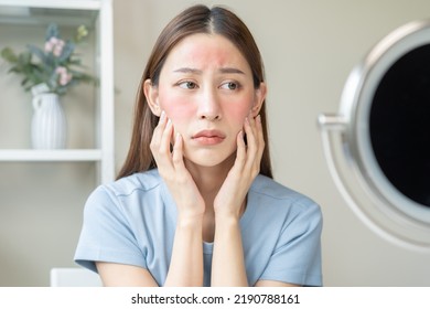 Dermatology, Scratch Asian Young Woman Looking At Mirror, Expression Worry And Itch, Itchy Allergy Or Allergic Sensitive Reaction, Red Spot Or Rash On Her Face. Beauty Care From Skin Problem Treatment