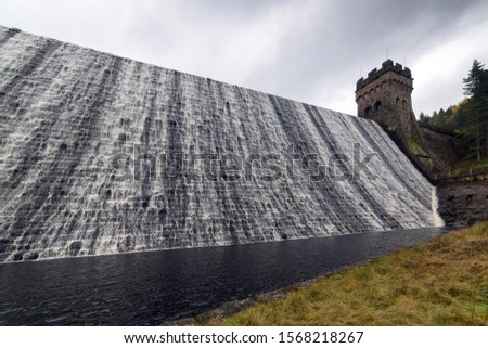 Derwent dam wall over flowing with cascading water. During the Second World War Derwent Reservoir was used for  practising the low-level flights for the "Dam Busters" raids in 1943