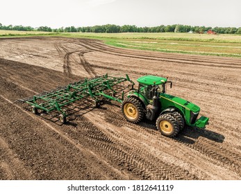 Des Moines, IA, USA, July 29, 2019: Green Tractor Performing Tillage In A Field, Aerial