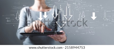 Descending arrows with business woman using a tablet computer
