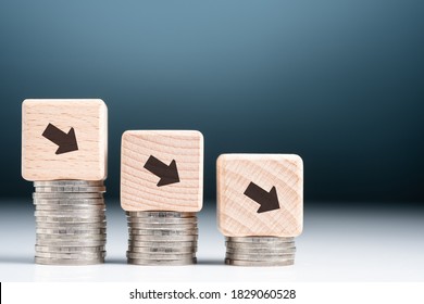 Descending finance graph, decrease coins heap with arrow sign on wood block as graph symbol, business and econnomic recession, credit decrease or less saving money - Shutterstock ID 1829060528