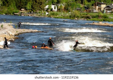 Deschutes River. Group of people river surfing in the whitewater park at Deschutes River. Bend, Oregon, USA.  May 21, 2017