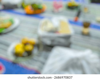 Description:
A blurred image showing a table with various dishes and food items placed on it.