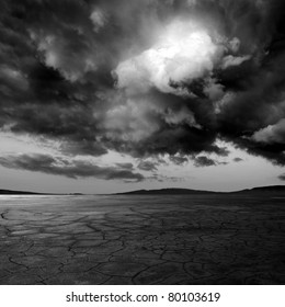 Desert With Cracked Ground And Dramatic Clouds.