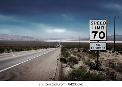 Desert Highway Road To Horizon With A Speed Limit Sign On A Side.