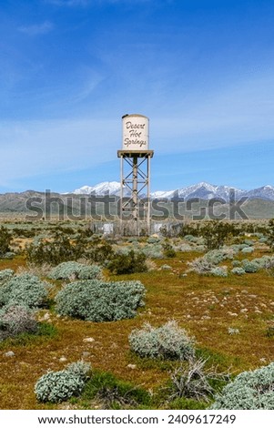 Desert Hot Springs, California water tower centered in frame with snow capped San Gorgonio Mountains in the background. Shot vertically.
