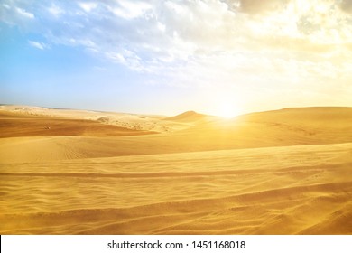 Desert landscape sand dunes at sunset sky near Qatar and Saudi Arabia. Khor Al Udeid, Persian Gulf, Middle East. Discovery and adventure travel concept. Sunlight over the desert dunes.