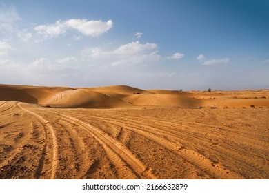 Desert landscape with tire tracks and trails with blue ski and fluffy clouds - Powered by Shutterstock