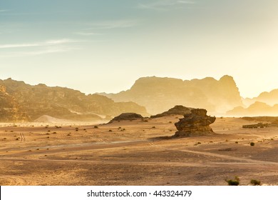 Desert Landscape of Wadi Rum in Jordan, with a sunset, stones, bushes and the sky. - Shutterstock ID 443324479