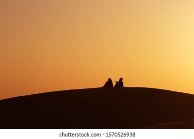 Desert Nomads On The Crest Of A Barchan At Sunset. Living In The Sands