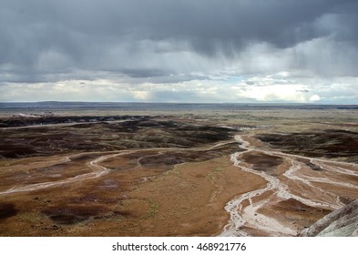 A Desert Plain Traversed By Washes And Creeks At Springtime,viewed From A Lookout. Dark Clouds Are Bearing Heavy Rains