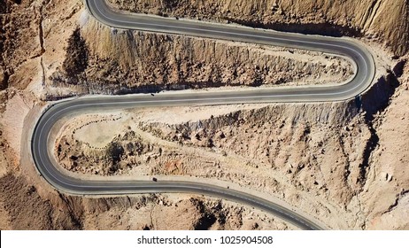 Desert road - Aerial image of traffic going up and down a  serpentine mountain road - Powered by Shutterstock