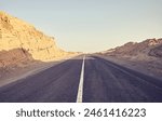 Desert road, front focus on asphalt, travel concept, color toning applied, Egypt.